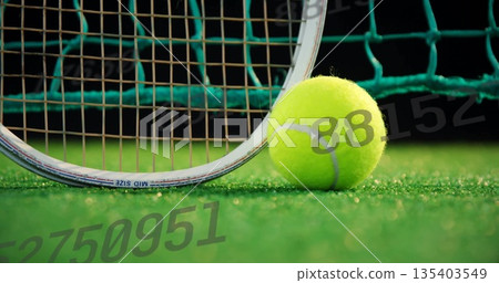 Resting tennis ball sitting on green court near racket frame and strings, with net, copy space Resting tennis ball sitting on green court near racket frame and strings, with net, copy space 135403549