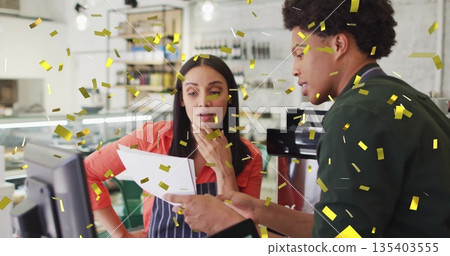 Reviewing printed report cafe staff wearing aprons at counter with espresso maker and gold confetti Reviewing printed report cafe staff wearing aprons at counter with espresso maker and gold confetti 135403555