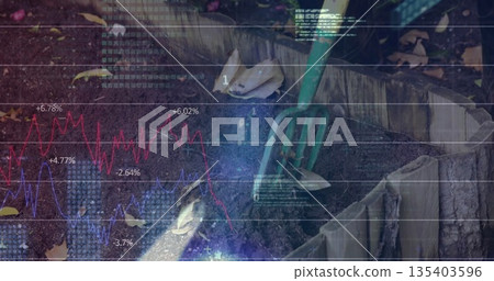 Holding gloved hands wielding trowel and cultivator at backyard raised bed, with financial overlay 135403596