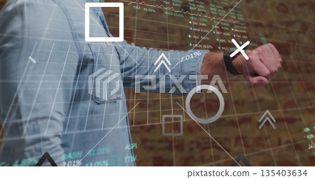 Man in denim shirt manipulating financial overlay in office, with smartwatch and stock symbols 135403634