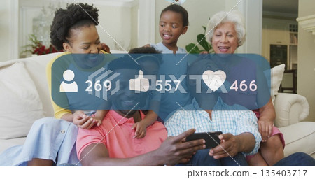Scrolling extended family sharing smartphone posts in living room, with social media overlay icons Scrolling extended family sharing smartphone posts in living room, with social media overlay icons 135403717
