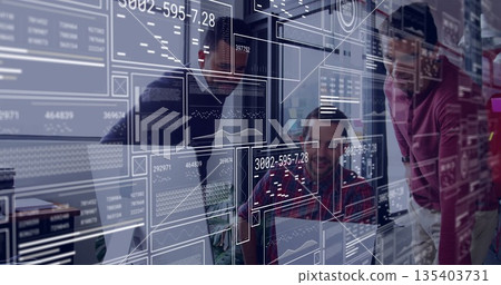Collaborating three men in casual clothes at desk in office, with digital displays and laptops 135403731