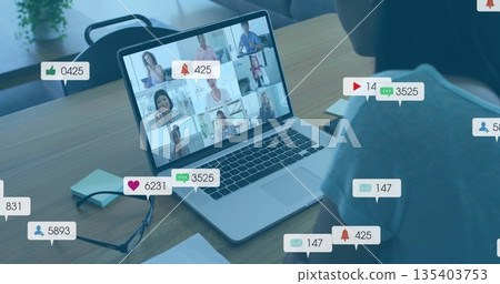 Viewing laptop showing nine remote team members at home desk with eyeglasses, floating social icons Viewing laptop showing nine remote team members at home desk with eyeglasses, floating social icons 135403753