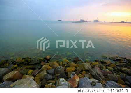 Soft waves on a rocky beach in the evening Soft waves on a rocky beach in the evening 135403943