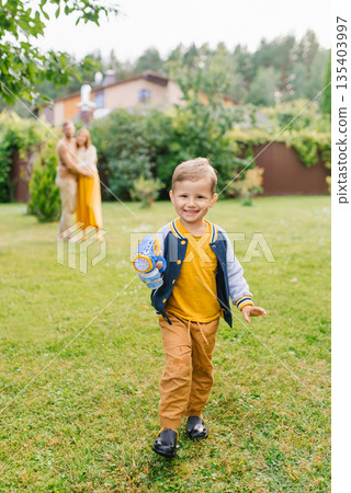 Joyful Boy Walking With Bubble Gun And Smiling Joyful Boy Walking With Bubble Gun And Smiling 135403997