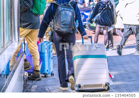 日本東京的城市景觀中隨處可見的行李箱。入境旅遊仍在繼續…一對外國遊客站在澀谷十字路口旁… 135404505
