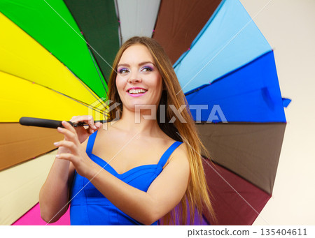 Woman in summer dress holds colorful umbrella Woman in summer dress holds colorful umbrella 135404611