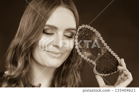 Closeup woman face with carnival mask on dark Closeup woman face with carnival mask on dark 135404621