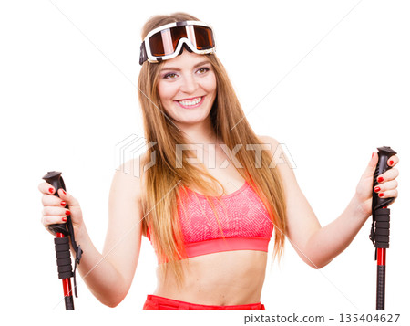 Woman wearing ski suit holding poles 135404627
