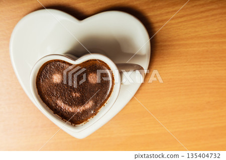 Coffee in heart shaped cup with smile face sign Coffee in heart shaped cup with smile face sign 135404732