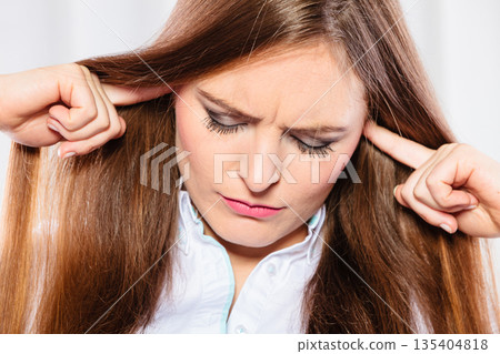 Stressed woman with closed eyes put fingers in ears, Stressed woman with closed eyes put fingers in ears, 135404818
