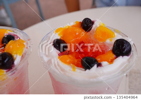 一杯色彩繽紛的刨冰飲品，裡面滿滿都是水果和奶油 135404964