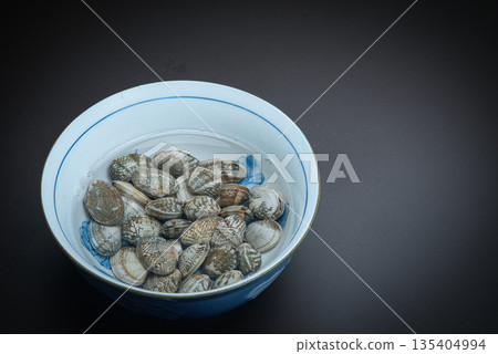 Clams in a container with salt water while being de-sanded Clams in a container with salt water while being de-sanded 135404994
