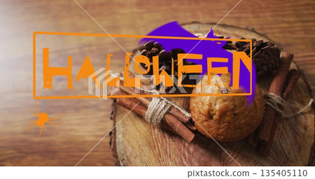 Halloween happy text image over muffin and cinnamon sticks on wooden surface 135405110