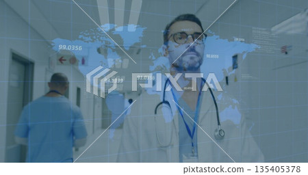 Standing male doctor wearing white coat and stethoscope in hospital hallway, with world map overlay Standing male doctor wearing white coat and stethoscope in hospital hallway, with world map overlay 135405378