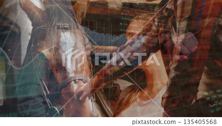 Plaid-shirted person petting brown horse muzzle with bridle in barn, with stock charts overlaying 135405568