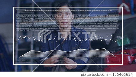 Mechanic in blue coveralls wiping with gray cloth in repair bay, red car hood, data overlay 135405634