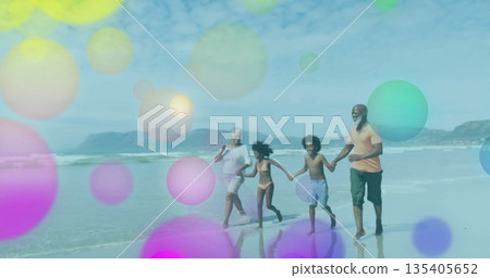 Walking senior adult, parent, children holding hands at shoreline with swimwear and pastel circles 135405652