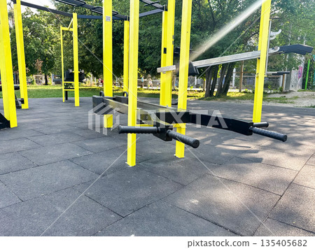 Outdoor gym equipment with yellow bars in a public park. 135405682