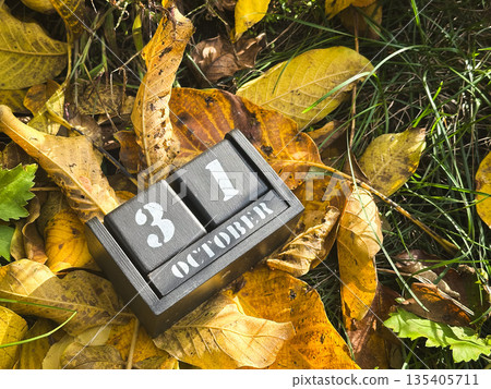 October calendar block on autumn leaves and grass. 135405711