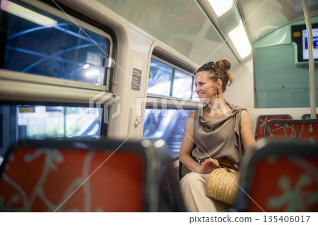 Smiling Woman Enjoys Scenic Train Ride to Paris 135406017
