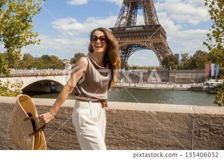 Smiling Woman with Straw Bag Enjoying Sunny Paris 135406032