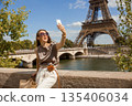 Happy Tourist Takes Selfie with Eiffel Tower Backdrop 135406034