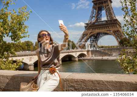 Happy Tourist Takes Selfie with Eiffel Tower Backdrop 135406034