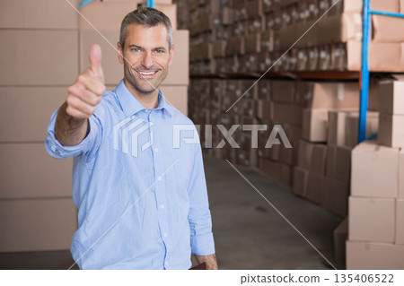 Man standing in storage facility giving thumbs-up holding clipboard near metal shelves and boxes Man standing in storage facility giving thumbs-up holding clipboard near metal shelves and boxes 135406522