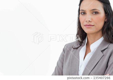 Businesswoman posing on right of studio portrait wearing grey blazer and white blouse, copy space 135407266