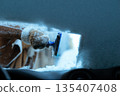 Clearing Snow from Windshield with Ice Scraper 135407408
