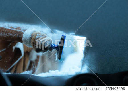 Clearing Snow from Windshield with Ice Scraper Clearing Snow from Windshield with Ice Scraper 135407408