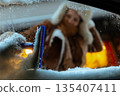 Woman Scraping Snow from Windshield at Night 135407411
