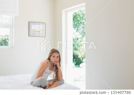 Female child sitting on bed in bedroom gazing through open doorway with framed artwork, copy space Female child sitting on bed in bedroom gazing through open doorway with framed artwork, copy space 135407780