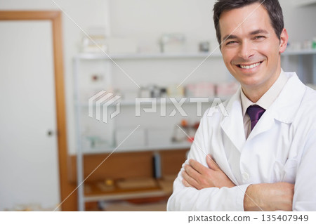 Male doctor wearing lab coat and purple necktie in exam room with supply shelves, copy space Male doctor wearing lab coat and purple necktie in exam room with supply shelves, copy space 135407949