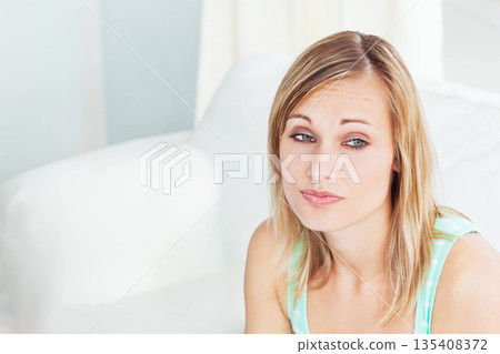 Woman wearing green top sitting on sofa cushion at home under sheer curtains, gazing, copy space Woman wearing green top sitting on sofa cushion at home under sheer curtains, gazing, copy space 135408372
