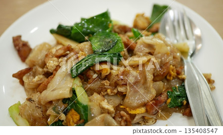 Pad see ew, stir fried noodles with chicken and egg. Pad is fried and see ew is soy sauce. Traditional food in Thailand. Origin in China. The Chinese influence on Thai cuisine with gourmet taste Pad see ew, stir fried noodles with chicken and egg. Pad is fried and see ew is soy sauce. Traditional food in Thailand. Origin in China. The Chinese influence on Thai cuisine with gourmet taste 135408547
