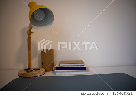 home workspace with colorful desk lamp notebooks and cardboard storage on clean white shelf home workspace with colorful desk lamp notebooks and cardboard storage on clean white shelf 135408721