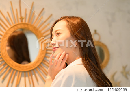 A woman standing in front of a mirror A woman standing in front of a mirror 135409069