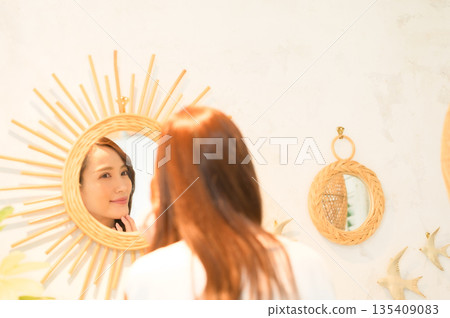 A woman standing in front of a mirror A woman standing in front of a mirror 135409083