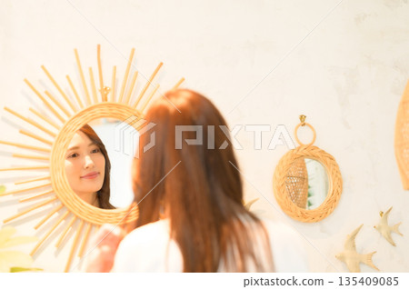 A woman standing in front of a mirror 135409085