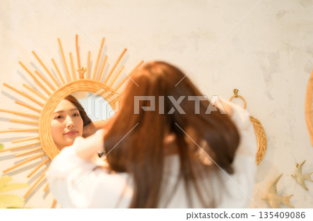 A woman standing in front of a mirror 135409086