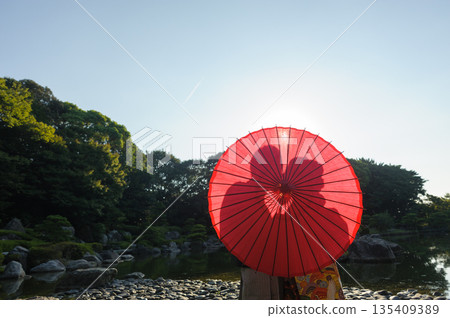 Silhouette of a Japanese wedding bride and groom making vows under a Japanese umbrella in a Japanese garden | Wedding advertising material Silhouette of a Japanese wedding bride and groom making vows under a Japanese umbrella in a Japanese garden | Wedding advertising material 135409389