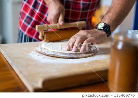 Detail of hands of men rolling the dough. Preparation for baking of traditional czech pastry. Homemade fresh food 135409770