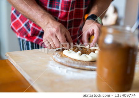 Detail of hands of men rolling the dough. Preparation for baking of traditional czech pastry. Homemade fresh food 135409774