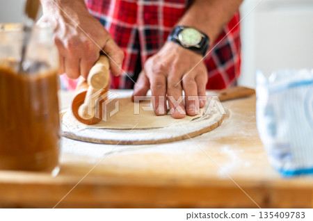 Detail of hands of men rolling the dough. Preparation for baking of traditional czech pastry. Homemade fresh food Detail of hands of men rolling the dough. Preparation for baking of traditional czech pastry. Homemade fresh food 135409783