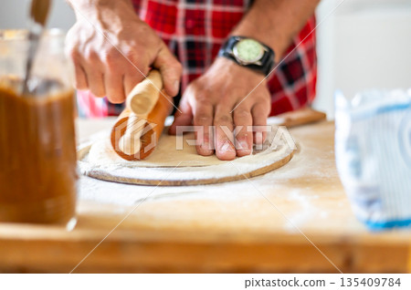 Detail of hands of men rolling the dough. Preparation for baking of traditional czech pastry. Homemade fresh food 135409784