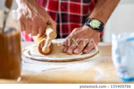 Detail of hands of men rolling the dough. Preparation for baking of traditional czech pastry. Homemade fresh food Detail of hands of men rolling the dough. Preparation for baking of traditional czech pastry. Homemade fresh food 135409786