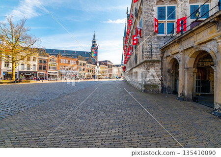 Gouda, Netherlands - 14.4.2022: Gouda main square and town hall. Blue sky, spring weather. Gouda, Netherlands - 14.4.2022: Gouda main square and town hall. Blue sky, spring weather. 135410090