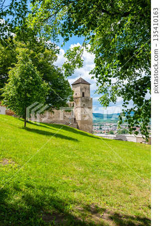 Ancient castle Trencin, Slovakia. Old fort on the hill, big walls and towers. Summer day, dramatic clouds before storm. 135410163